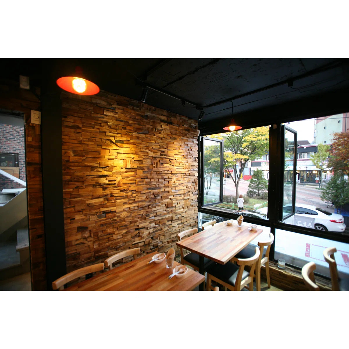 Restaurant interior with wooden tables and chairs near a window view.