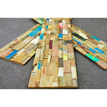 Wooden art piece with multicolored patches on a gray surface